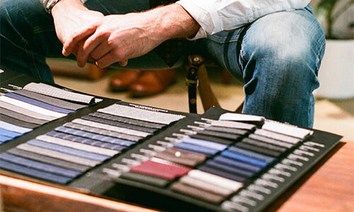 groom selecting from a book of fabric swatches