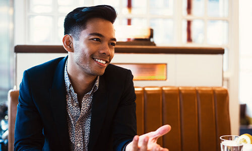 groom speaking to a clothier at a table